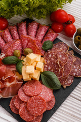 Cold smoked meat plate on a rustic wooden background