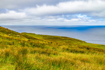 Cliffs of Moher trail with farm fields and ocean