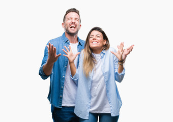 Young couple in love over isolated background celebrating mad and crazy for success with arms...