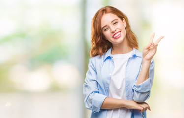 Fototapeta premium Young beautiful business woman over isolated background smiling with happy face winking at the camera doing victory sign. Number two.