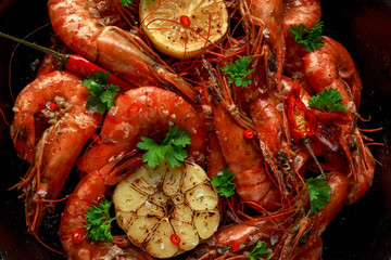 Tiger prawns fried in butter with, lemon juice, garlic and white wine served in cast iron skillet with parsley