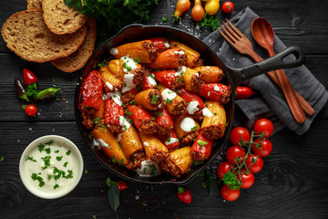 Sausage meat, mince and rice Stuffed sweet mini bell peppers baked in cast iron skillet, pan topped...