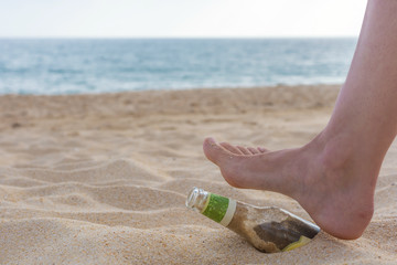 Frauenfuß tritt auf Müll am Strand