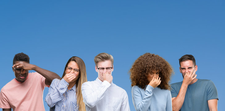 Composition of group of friends over blue blackground smelling something stinky and disgusting, intolerable smell, holding breath with fingers on nose. Bad smells concept.