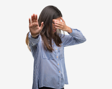 Young beautiful hispanic business woman covering eyes with hands and doing stop gesture with sad and fear expression. Embarrassed and negative concept.