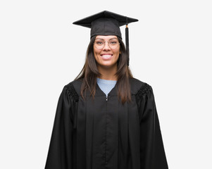 Young hispanic woman wearing graduated cap and uniform with a happy and cool smile on face. Lucky person.