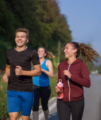 young people jogging on country road