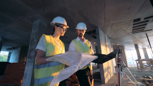 Workers, architects checking a building plan, close up.
