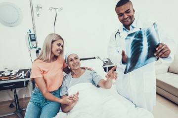 Woman with Mother. Cancer. Doctor looks X-ray.