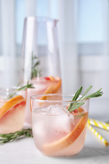 Refreshing grapefruit cocktail with rosemary on table