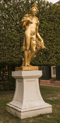 Obraz premium Schwetzingen Palace Garden. Golden statue of Diana the huntress with a boar‘s head. Schwetzingen, Baden Wuerttemberg, Germany, Europe