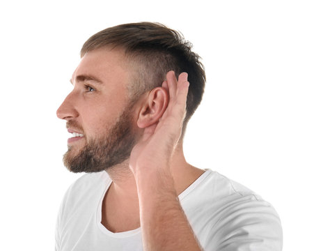 Young man with hearing problem on white background