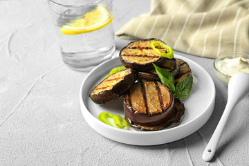 Plate with fried eggplant slices on table