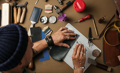 Review of the manufacture of the custom made poketbook in the leathercraft workshop. High angle...