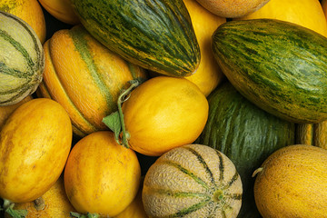 Fresh tasty ripe melons as background, top view