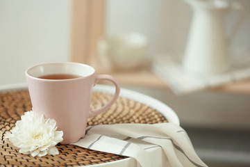 Cup of tea and flower on table indoors