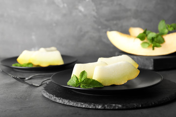 Slices of fresh ripe melon on table against gray background