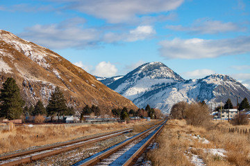 Railroad Tracks Leading to Snowy Mountain Scene