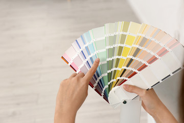 Female interior designer with color palette samples indoors, closeup. Space for text