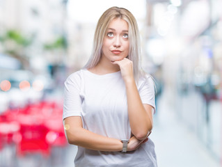 Fototapeta premium Young blonde woman over isolated background with hand on chin thinking about question, pensive expression. Smiling with thoughtful face. Doubt concept.