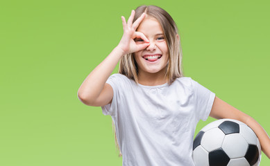 Young beautiful girl holding soccer football ball over isolated background with happy face smiling...