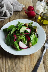 Freshly prepared salad made of greens, red radishes and green olives