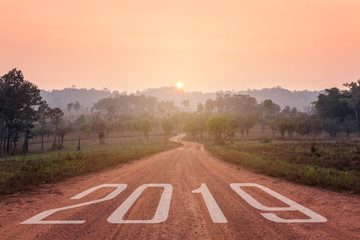 Empty country road towards the rising sun to upcoming, 2019 New year concept