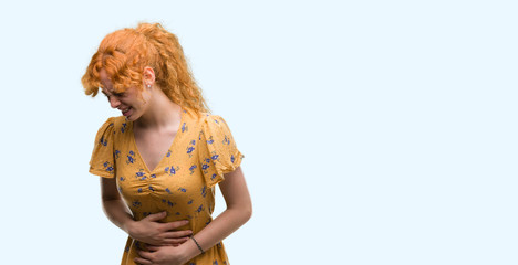 Young redhead woman with hand on stomach because indigestion, painful illness feeling unwell. Ache concept.