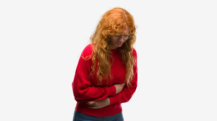 Young redhead woman wearing red sweater with hand on stomach because nausea, painful disease feeling unwell. Ache concept.