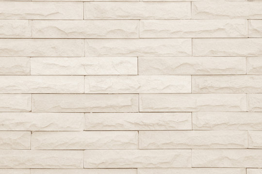 Seamless Cream pattern of decorative brick sandstone wall surface with concrete of modern style design decorative uneven have cracked realmasonry wall of multicolored stones or blocks with cement.
