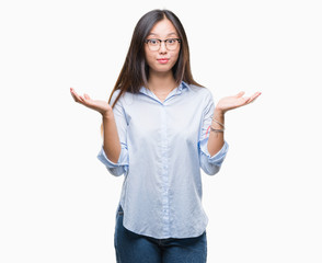 Young asian business woman wearing glasses over isolated background clueless and confused...
