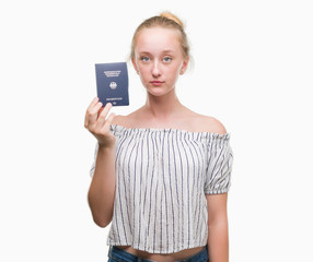 Blonde teenager woman holding passport of Germany with a confident expression on smart face thinking serious