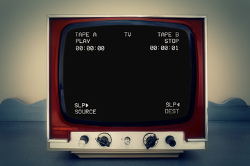 A retro vintage TV showing a clean black VHS tape screen tracking a signal coming from a double deck. Cool retro vintage backdrop.
