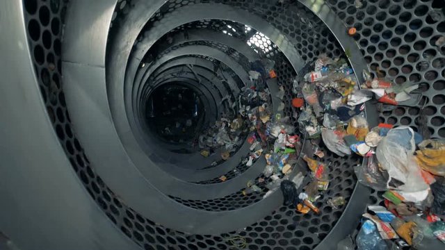 Lots of trash in a recycling center. Recyclable garbage rotates in a special machine at a plant.