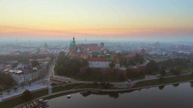Krakow, Poland. Wawel royal Castle and Cathedral, Vistula River. Cracow old city with historic churches in the background. Aerial 4K flyby video at sunrise in summer