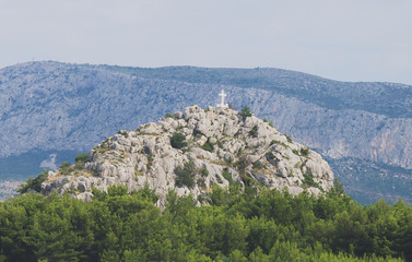 Naklejka premium Holy cross on the rocky mountain hill.