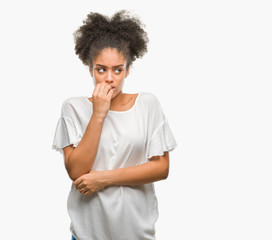 Fototapeta na wymiar Young afro american woman over isolated background looking stressed and nervous with hands on mouth biting nails. Anxiety problem.
