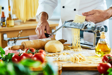 Chef making noodles with kitchen in background