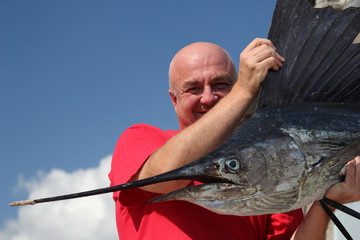 fishing for a sailfish (Istiophorus platypterus). Fisherman with sailfish (fish-sword). fishing in...