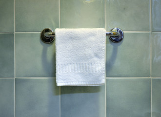 Toalla blanca colgada en un baño