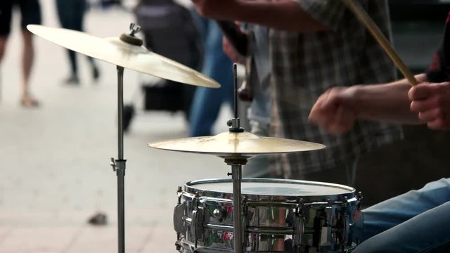 Male hands with drum sticks. Close up. Rock band playing outdoor.