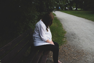 lonely mature pregnant woman in the park