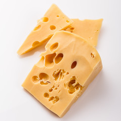 Piece and slices of cheese on a white background