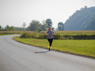 woman jogging along a country road