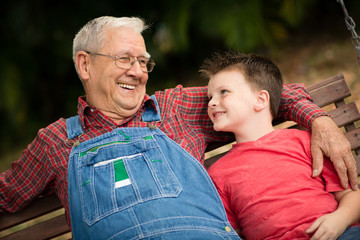 Happy Great Grandfather and Great Grandson Sitting Outside