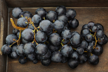 Blue grapes in wooden box, top view