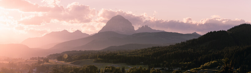 Sun peaks out from behind the clouds over Crowsnest Mountain and Seven Sisters Mountain
