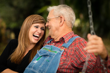 Fototapeta premium Grandfather and Granddaughter Laughing Together on Swing