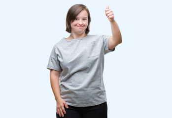 Young adult woman with down syndrome over isolated background doing happy thumbs up gesture with hand. Approving expression looking at the camera with showing success.