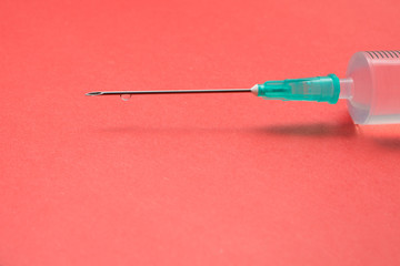 Needle of syringe on a red background